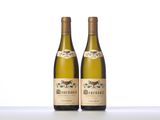 two bottles of white wine sitting on top of a table