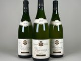 trois bouteilles de vin sont alignées sur une table