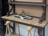 un bureau en bois avec un plateau en marbre, placé dans un coin de la pièce
