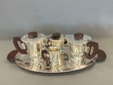 a silver tray with four silver cups and saucers on it