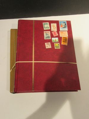 un livre rouge orné de timbres, posé sur une table