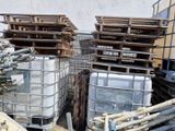 un tas de cuves métalliques et de palettes en bois empilées les unes sur les autres