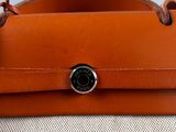 an orange leather case with a camera attached to it