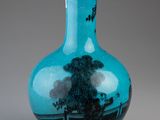 blue glass vase with a tree in the middle of it on a gray surface