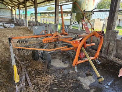 a man standing next to a tractor with a plow attached to it