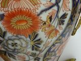 a vase that has a handle on it with flowers on it
