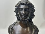 a bronze bust of a woman with long hair on a marble base