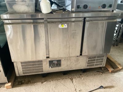 two stainless steel refrigerators sitting on a pallet in a kitchen