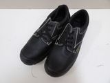 pair of black shoes with white stitching on them sitting on a white surface