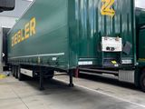 a green semi truck that is parked on the side of the road