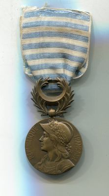 une médaille entourée d'un ruban, posée sur un fond blanc