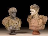 two busts of roman men on pedestals against a black background