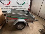 La remorque est garée dans le garage, à côté de cartons et encore des cartons