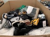 a cardboard box filled with shoes and other items