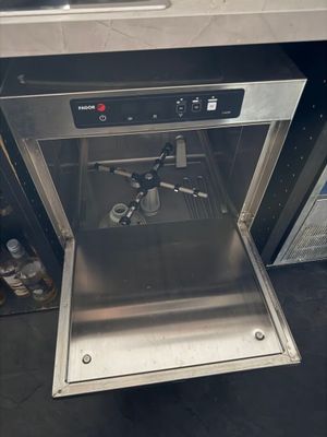 a stainless steel dishwasher that is open on the counter