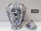 a blue and white vase with a lid sitting next to another vase