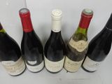six bottles of wine are lined up in a row on a table