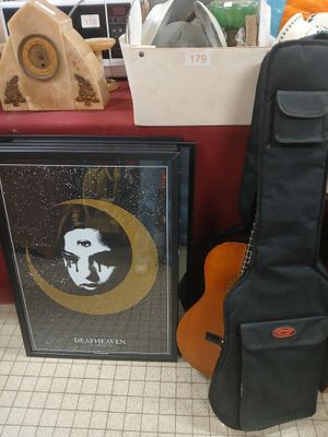 a guitar, a guitar case, and a picture on the floor
