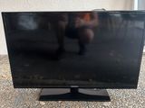 une télévision à écran plat posée sur un sol recouvert de moquette