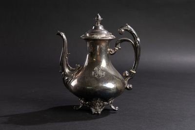 une théière ancienne en argent avec un couvercle, sur fond noir