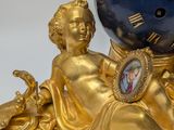 a gold and blue clock sitting on top of a table