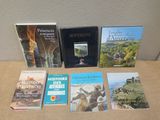 several books are sitting on a table in front of a wall