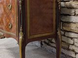 a small cabinet with a marble top in front of a stone wall