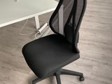 a black office chair sitting in front of a white desk
