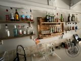 many bottles and glasses on the shelves above the kitchen sink