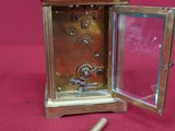 a small brass clock with a key inside of it