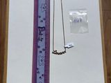 une photo d'un collier et d'une règle posés sur une table