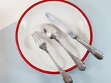 a red and white plate with silverware on it