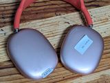 pair of pink headphones sitting on top of a wooden table