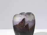 une image représentant un vase orné d'un paysage de montagne