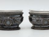 two silver vases sitting next to each other on a table