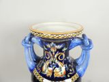 a blue vase with a handle on a black stand