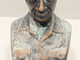 statue of a man with goggles on his head on a white surface
