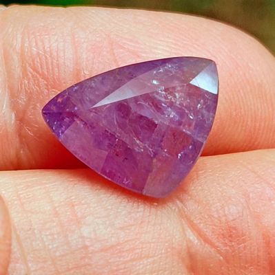 Quelqu'un tient dans sa main une très jolie pierre violette.