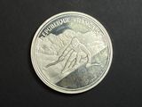 a silver coin with a picture of a person on it