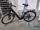 un vélo garé dans une pièce, à côté d'une pile de cartons