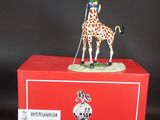 une figurine de girafe posée sur une boîte rouge