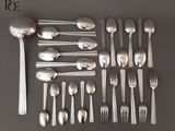 un grand nombre de cuillères et de fourchettes en argent disposées sur une table