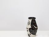 two black and white vases sitting on top of a white table