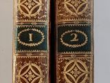 une paire de livres anciens posés sur une surface blanche