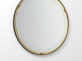 Le miroir rond est accroché au mur de la pièce.