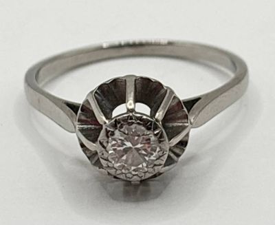 gros plan d'une bague en diamant sur une surface blanche