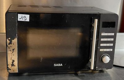 a black microwave sitting on a counter top with a price tag on it