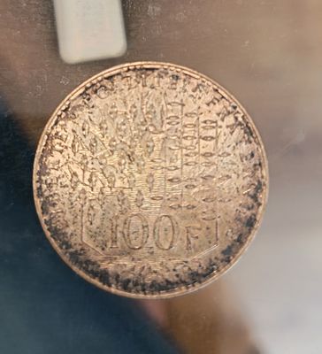 une pièce de monnaie posée sur une table, dans une vitrine en verre