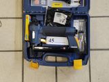 une boîte à outils bleue contenant des outils, posée sur un sol carrelé