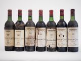 six bouteilles de vin sont alignées sur une surface blanche